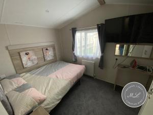 En eller flere senge i et værelse på Meadow View 171 - Golden Palm - Central heating, WiFi, pet friendly, bed linen - Meadow Lakes Caravan & Lodge Hire