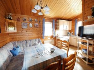 sala de estar con sofá, mesa y cocina en Ferienhaus Nr 20, Typ B, Feriendorf Jägerpark, Bayerischer Wald en Viechtach