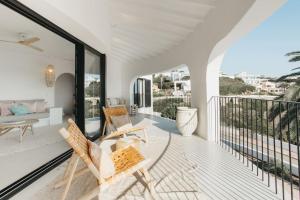 a living room with two chairs on a balcony at Villa Alma luxe & sea views in Cala Llonga