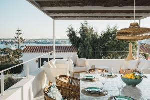 a patio with a table and chairs on a balcony at Villa Alma luxe & sea views in Cala Llonga