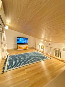 a room with a large blue rug on a wooden floor at Bandra Cottage (With Yard) in Mumbai