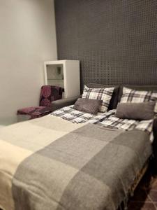 Un dormitorio con una cama con una manta a cuadros. en Apartment in the city center, en Rovaniemi 8 fotos más