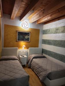 ヴィチェンツァにあるResidence San Miguel 8のベッドルーム1室(ベッド2台付)が備わります。壁には絵画が飾られています。