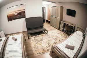 um quarto com duas camas e uma cadeira em Ride More Activity Center em Miercurea-Ciuc