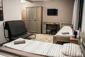 ein Zimmer mit zwei Betten, einem Stuhl und einem Schreibtisch in der Unterkunft Ride More Activity Center in Miercurea Ciuc