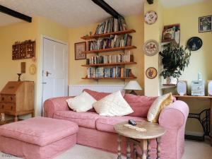 a living room with a pink couch and a table at South Side in West Runton