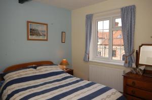 a bedroom with a bed and a window at South Side in West Runton