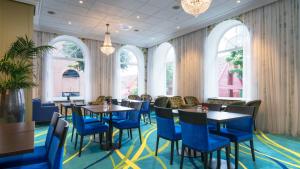 a restaurant with blue chairs and tables and windows at Thon Hotel Rosenkrantz Bergen in Bergen