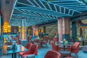 a restaurant with blue ceilings and tables and chairs at Echor Palm Bliss Riverside Resort & Spa Kasol in Kasol