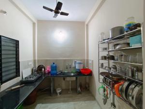 a kitchen with a sink and a counter with a fan at Hari Har HOME STAY FULLY AC in Ujjain