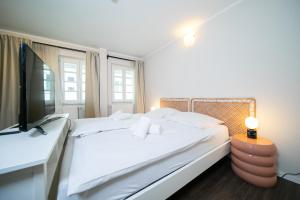 a bedroom with a large bed and a television at Favorite Stays -Suite and More - Altstadt in Düsseldorf