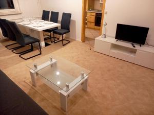 uma sala de estar com uma mesa e cadeiras e uma televisão em Nice Apartment in Jena em Jena