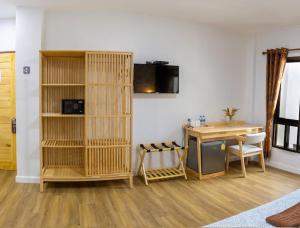 Cette chambre comprend un bureau, une table et une étagère à livres. dans l'établissement Thai Life Guesthouse Khaolak, à Khao Lak