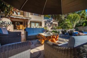 een patio met stoelen, een tafel en een parasol bij Fustera Villa El Salvador in Benissa