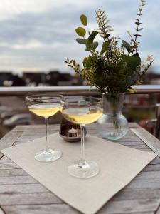 比蘇姆的住宿－Villanelle - Spa & Meer，两杯酒杯坐在桌子上,带花瓶