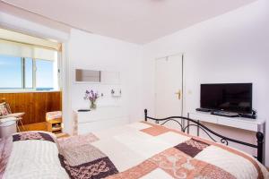 a bedroom with a bed and a flat screen tv at Leo Apartment in Dubrovnik