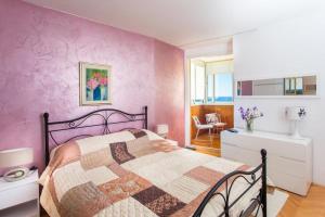 1 dormitorio con cama y pared púrpura en Leo Apartment en Dubrovnik