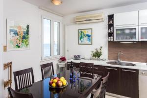 a kitchen with a table with a bowl of fruit on it at Leo Apartment in Dubrovnik