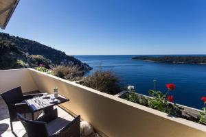 een tafel en stoelen op een balkon met uitzicht op het water bij Leo Apartment in Dubrovnik