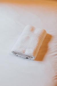 a white towel sitting on top of a bed at Rural Log Cabin in Snowdonia - 2 Bedrooms & Parking in Ffestiniog