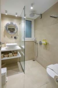a bathroom with a glass shower and a sink at Acropolis Urban Oasis in Athens