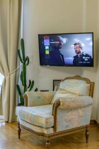 a living room with a chair and a flat screen tv at Acropolis Urban Oasis in Athens