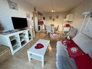 ein Wohnzimmer mit einem Sofa und einem TV in der Unterkunft T3 La Grande Chaume Le Sauze in Enchastrayes