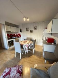 eine Küche und ein Esszimmer mit einem Tisch und Stühlen in der Unterkunft T3 La Grande Chaume Le Sauze in Enchastrayes