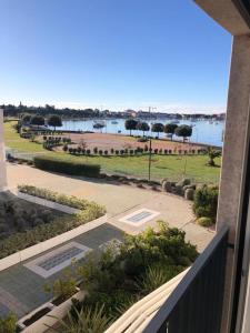 a balcony with a view of a park and a body of water at LUX VISTA Suite in Umag