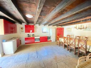 a kitchen with red cabinets and a table and chairs at Villa Angiolina in Višnjan