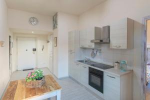 a kitchen with white cabinets and a table with a plant at L'acciughina in Portoferraio +8 photos