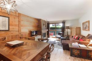 a living room with a wooden wall at Clos des Vorgeats - Duplex Beside Golf Course - Patio - UTMB in Chamonix-Mont-Blanc