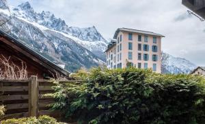 a building with a mountain in the background at Clos des Vorgeats - Duplex Beside Golf Course - Patio - UTMB in Chamonix-Mont-Blanc