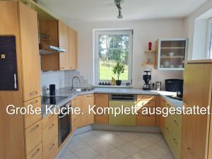 a kitchen with wooden cabinets and a window at Aparts Lakeview -Gerlitzen -Ossiacher See -Ski in Tratten
