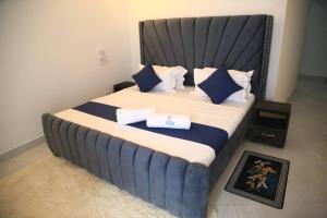 ein Schlafzimmer mit einem großen Bett mit blauen und weißen Kissen in der Unterkunft Oceanview Vacation House in Mombasa Town Lenda Homes in Mombasa