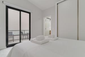 uma cama branca com duas almofadas em cima em Graça House em Machico