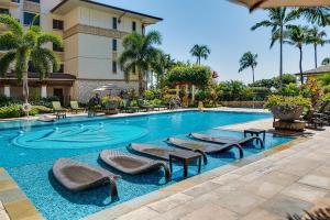 a swimming pool with lounge chairs and a hotel at Ko Olina Beach Villas O1404 in Kapolei