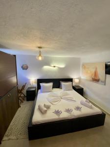Schlafzimmer mit einem Bett mit weißer Bettwäsche und Kissen in der Unterkunft Sun Oniro Studio in Samothráki