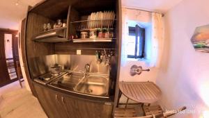 una pequeña cocina con fregadero y un banco al lado en Sun Oniro Studio en Samotracia