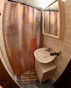 uma casa de banho com um lavatório e uma cortina de chuveiro em Sun Oniro Studio em Samothráki