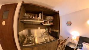 una cocina con fregadero en un armario de madera en Sun Oniro Studio, en Samotracia