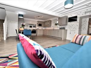 a living room with a blue couch and a kitchen at 4 Bed in Ilfracombe 45121 in Ilfracombe