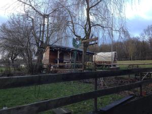 uma cabana de madeira num campo ao lado de uma cerca em Scholz 