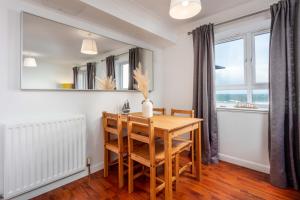 a dining room with a wooden table and chairs at The Original Donnini Apartment in Ayr