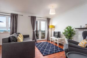 a living room with two couches and a television at The Original Donnini Apartment in Ayr