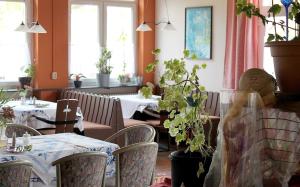 un comedor con mesas, sillas y plantas en Ferienhaus Nr 20, Typ B, Feriendorf Jägerpark, Bayerischer Wald en Viechtach