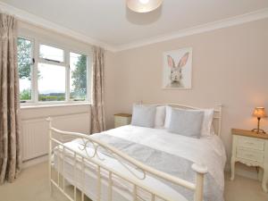 a white bedroom with a bed and a window at 3 Bed in Tansley 57013 in Tansley