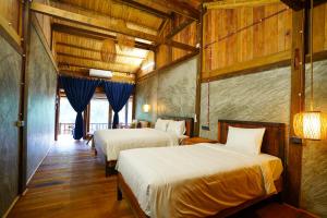 two beds in a room with wooden walls at Ba Be Jungle Houses in Ba Be18