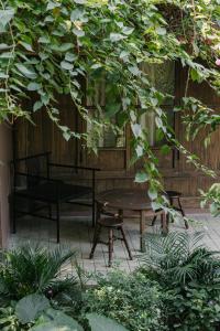 a patio with a table and a bench under a tree at TOKI Retreat Vân Long in Ninh Binh