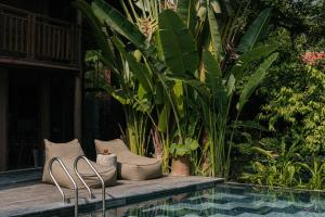 a couple of chairs sitting next to a pool at Toki Artisan Lodge Vân Long in Ninh Binh